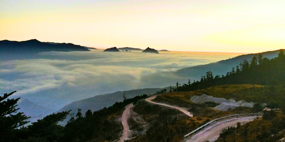 Golden sunrise illuminating snow‑covered Himalayan peaks and valleys near Tawang in Arunachal Pradesh